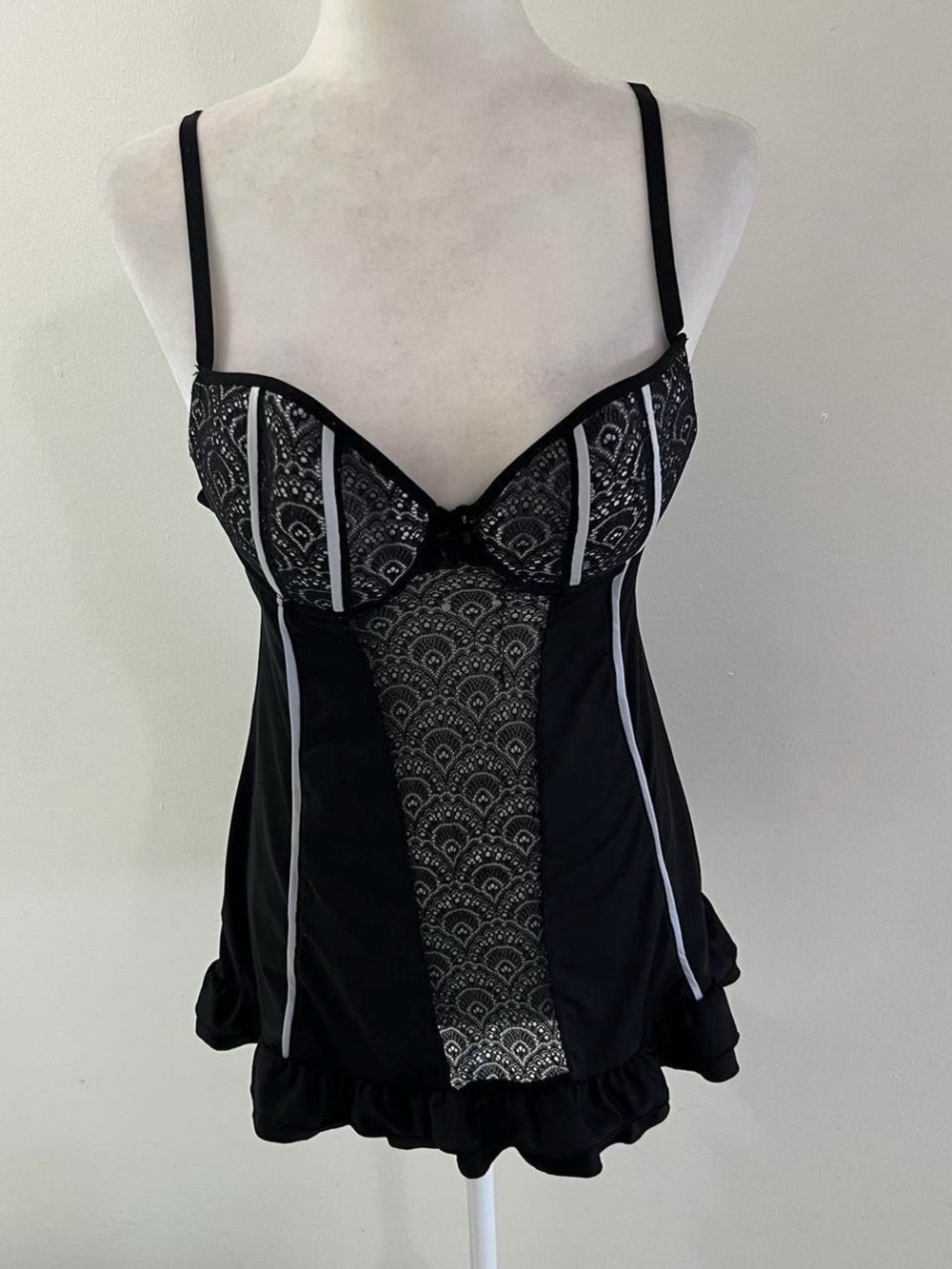 Black lingerie corset dress with white lace detailing and an open back